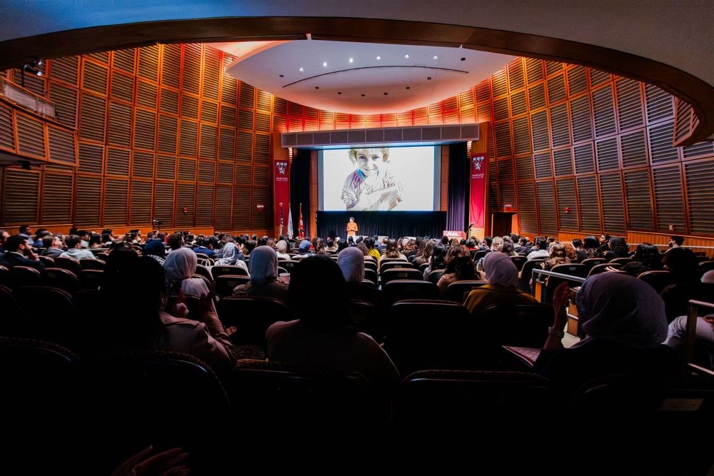 Packed auditorium at the Arab Conference at Harvard, speaker on stage in front of a large screen