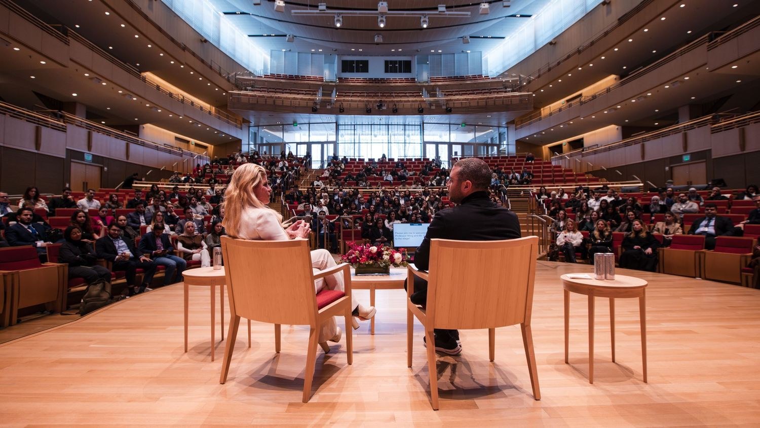 Two speakers on stage during a keynote at the Arab Conference at Harvard, audience watching