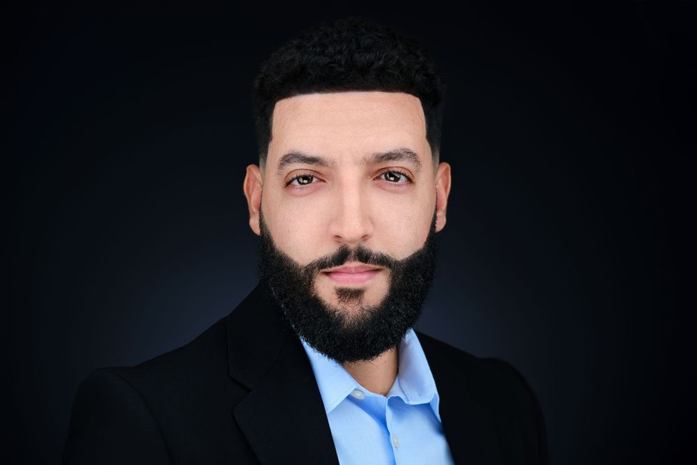Professional headshot on a dark studio background